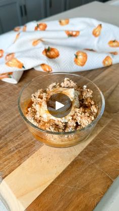 a glass bowl filled with food on top of a wooden cutting board