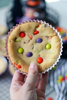 a person holding up a cookie with candy on it