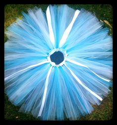 a blue and white tutule on the ground with grass in the foreground