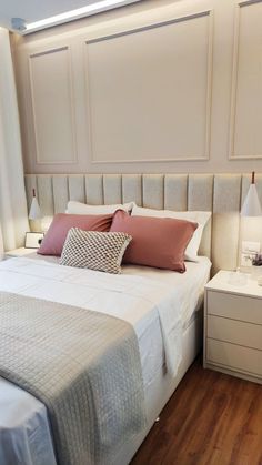 a bedroom with a bed, nightstands and two lamps on either side of the bed