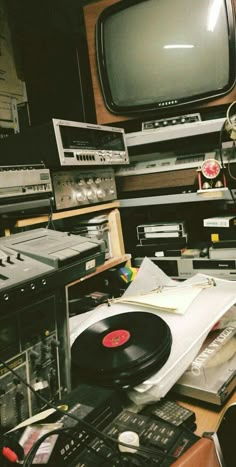 an old fashioned record player sitting on top of a table next to a television set