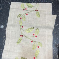 a piece of cloth with holly and red berries on it