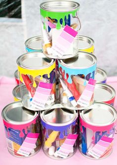 a stack of paint cans sitting on top of a pink table