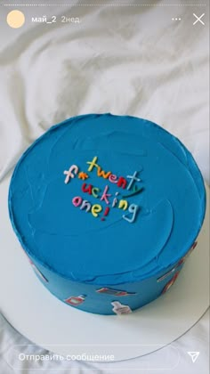 a blue cake sitting on top of a white plate with the words twenty and one