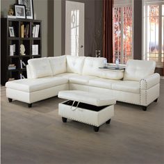 a white leather sectional sofa with ottoman and footstool in a living room setting