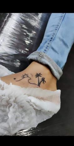 a woman's foot with a palm tree tattoo on it