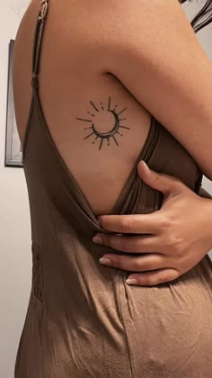 a woman with a sun tattoo on her shoulder