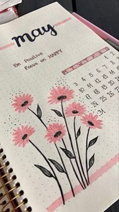 a calendar with pink flowers on it and the word may written in cursive writing