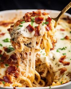 a close up of a spoon full of pasta with bacon and cheese on it, being lifted from a casserole dish