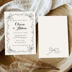 the wedding stationery is laid out on a wooden plate