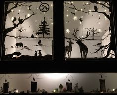 the silhouettes of animals are on display behind frosted glass windows with christmas lights