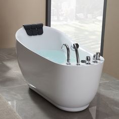 a white bath tub sitting on top of a tiled floor