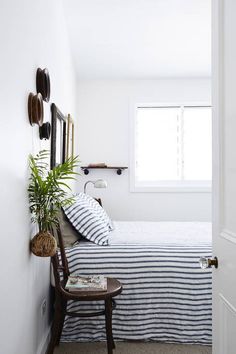 a bedroom with white walls and striped bedding