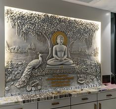 a buddha statue sitting on top of a counter in front of a wall with birds