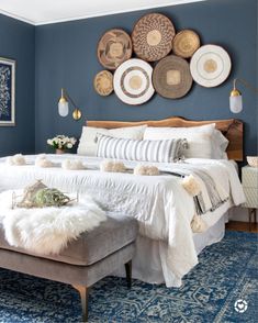 a bedroom with blue walls and white bedding