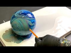 someone is painting an object with blue and green paint