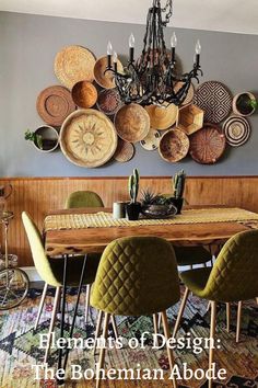 a dining room table with green chairs and baskets on the wall above it, in front of a chandelier