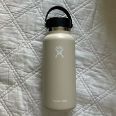 a white water bottle sitting on top of a bed