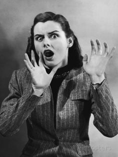 an old photo of a woman with her hands in front of her face and mouth wide open