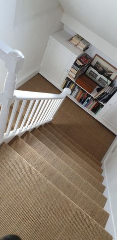 a stair case with bookshelves and carpet on the floor