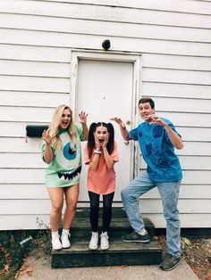 three people standing on steps with their hands in the air