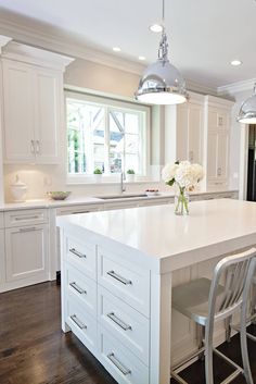 a large kitchen with white cabinets and an island