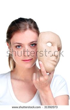 a woman holding a mask in front of her face