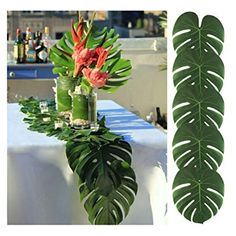 a table topped with vases filled with flowers next to a green leafy plant