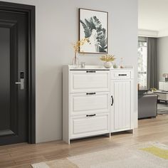 a white cabinet sitting in the middle of a living room next to a black door