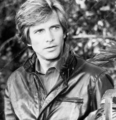 an old black and white photo of a man in a leather jacket holding a bird