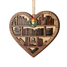 a wooden heart shaped ornament with books on it