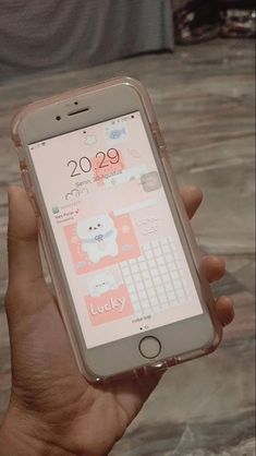 a person holding an iphone in their hand with the screen showing hello kitty on it