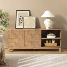 a living room scene with focus on the sideboard and lamp in the foreground