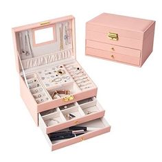 an open pink jewelry box sitting on top of a white table