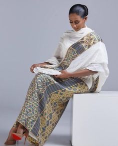 This Shimena Habesha dress is a true masterpiece that combines traditional elegance with modern style. The dress features an intricate pattern that is carefully crafted to create a stunning visual effect. The pattern is complemented by a beautiful Tibeb design, which adds a touch of traditional charm to the overall design. The dress is designed to fit comfortably and flatteringly, with a fitted bodice and a full skirt that flows beautifully as you move. The dress is made with high-quality fabric Eritrean Dress, Ethiopian Clothing, Habesha Dress, Ethiopian Traditional Dress, Ethiopian Dress, Habesha Kemis, Cultural Events, Jan 11, Full Skirt