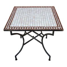 a table that is made out of metal and has a white tile top with red dots on