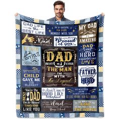 a man is holding up a blanket that has many different words on it, including dad and