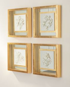 three gold framed flowers on a white wall