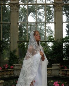 a woman in a white wedding dress and veil