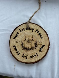 a wood slice with candles on it that says, have lovely peace and love for you