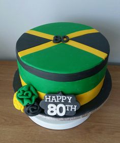 a green and yellow birthday cake with the number 80 on it's side, sitting on a wooden table