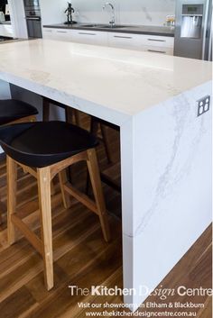 a kitchen island with two stools next to it