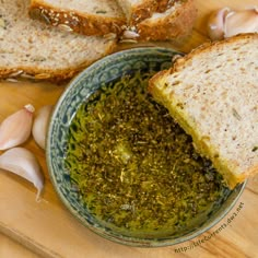 garlic bread and pesto in a bowl on a cutting board