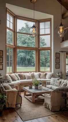 a living room filled with furniture and large windows