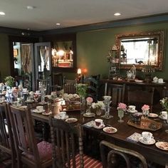 the dining room table is set with many plates and cups