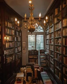 a chandelier hanging from the ceiling in a library filled with books