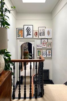 an entry way with pictures on the wall and stairs leading up to it's second floor