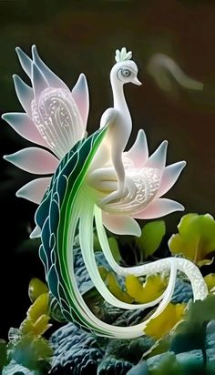 a white bird sitting on top of a green and pink flower next to water lilies