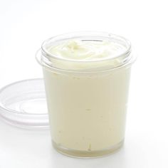 a glass container filled with cream sitting on top of a white table