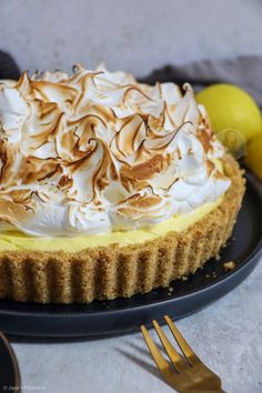 a lemon meringue pie on a black plate